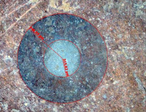 Kalottenschliff unter dem Mikroskop: Schichten eines Überzugs als konzentrische Ringe